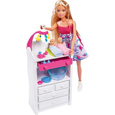 Barbie mit zwei Babys auf einem Wickeltisch, hält ein Mobile über ihnen dazu Zubehör fürs Kinderzimmer. Barbie mit zwei Babys auf einem Wickeltisch, hält ein Mobile über ihnen dazu Zubehör fürs Kinderzimmer.