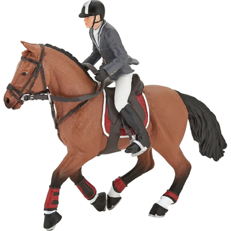 Spielfigur eines Reiters mit Helm und Anzug auf einem braunen Pferd mit rot-weißer Ausrüstung.