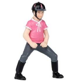 Spielfigur einer Person mit pinkem Shirt, Helm, Stiefeln und grauer Hose steht breitbeinig.
