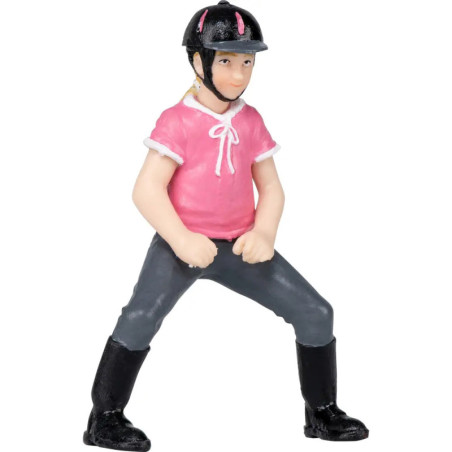 Spielfigur einer Person mit pinkem Shirt, Helm, Stiefeln und grauer Hose steht breitbeinig.