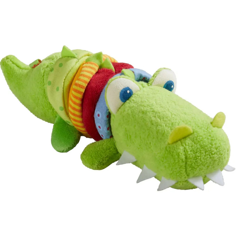 Plüsch-Krokodil in Grün mit bunten Ringen um den Körper und großen Augen. Plüsch-Krokodil in Grün mit bunten Ringen um den Körper und großen Augen.