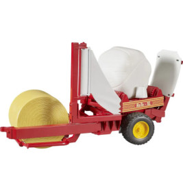 Rot-gelbe Ballenwickelmaschine mit einem gewickelten und einem ungewickelten Ballen auf einer Ausstellungsfläche.