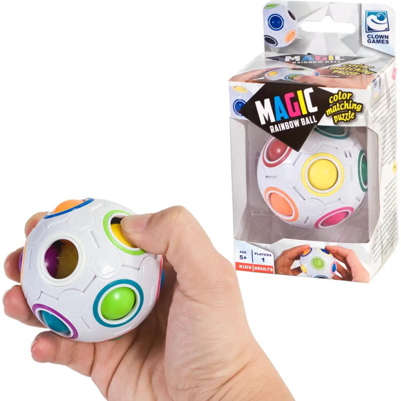 Eine Hand hält einen Magic Rainbow Ball, im Hintergrund ist die Verpackung des Puzzles zu sehen.