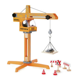 Holzspielzeug-Kran mit Verkehrsleitkegeln, Absperrungen, Straßenschildern und Haken, der einen Block hebt.