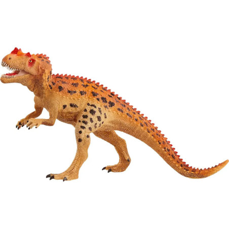 Spielzeugmodell eines braun-orangenen Dinosauriers mit roten Hörnern und schwarzen Flecken auf zwei Beinen. Spielzeugmodell eines braun-orangenen Dinosauriers mit roten Hörnern und schwarzen Flecken auf zwei Beinen.