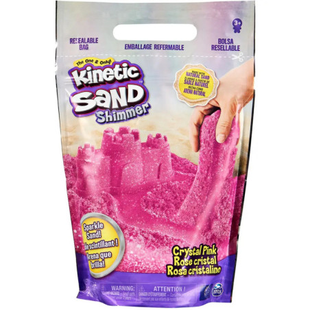 Eine Packung Kinetic Sand Shimmer Crystal Pink, eine Hand formt daraus eine rosa Sandburg. Eine Packung Kinetic Sand Shimmer Crystal Pink, eine Hand formt daraus eine rosa Sandburg.