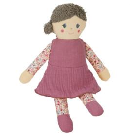 Stoffpuppe mit braunen Haaren, pinkem Kleid und geblümten Armen und Beinen sitzt aufrecht.