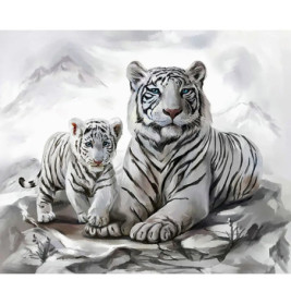 Ein weißer Tiger und sein Junges ruhen auf schneebedeckten Felsen vor einer Bergkulisse.