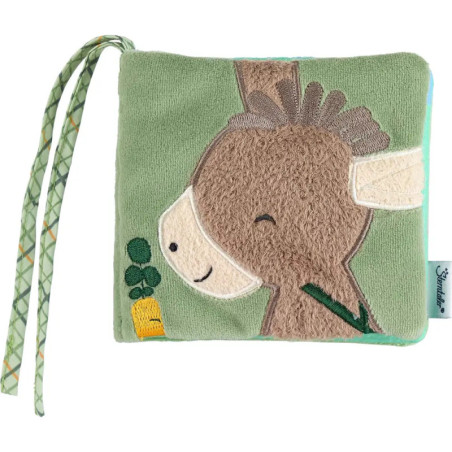 Weiches, grünes Babybuch mit gesticktem Esel, einer Möhre und gemusterten Stoffbändern. Weiches, grünes Babybuch mit gesticktem Esel, einer Möhre und gemusterten Stoffbändern.