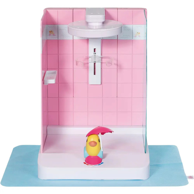 Ein Spielzeugvogel mit Schirm sitzt in einer rosa-weißen Dusche auf einer blauen Matte. Ein Spielzeugvogel mit Schirm sitzt in einer rosa-weißen Dusche auf einer blauen Matte.
