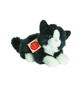 Schwarz-weiße Plüschkatze mit blauen Augen und rotem Etikett liegt auf weißem Hintergrund.