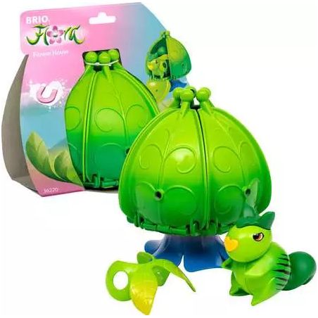 Grünes Blumen-Spielzeughaus mit kleinem Tier und Verpackung im Hintergrund.