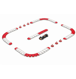 Ein Spielzeugauto fährt auf einer Strecke mit rot-weißen Barrieren und orangenen Kegeln vor weißem Hintergrund.