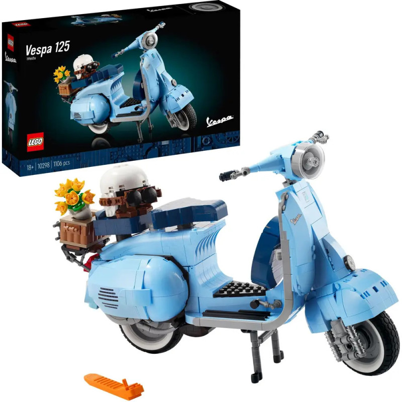 Das LEGO Vespa 125 Set in Hellblau mit Blumen und Helm steht fertig aufgebaut vor der Verpackung.