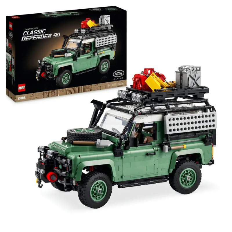 LEGO Classic Defender 90 Modellauto mit Dachgepäckträger, Ausrüstung und Verpackung im Hintergrund.