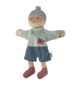 Stoffpuppe mit Brille, grauem Dutt, blauem Outfit sowie roter Tasche und roten Schuhen.