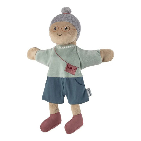Stoffpuppe mit Brille, grauem Dutt, blauem Outfit sowie roter Tasche und roten Schuhen.