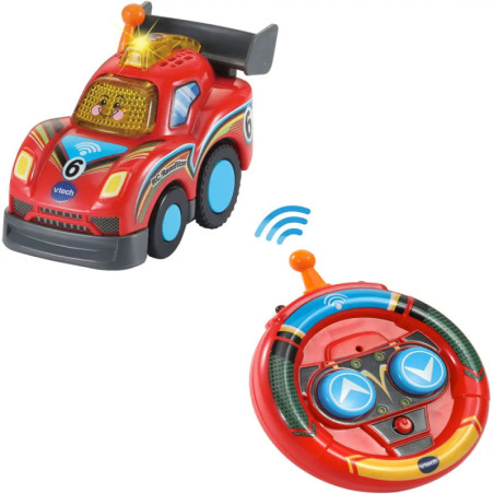 Rotes Spielzeugauto mit blauen Rädern und lachendem Gesicht neben rundem roten Controller mit blauen Tasten.