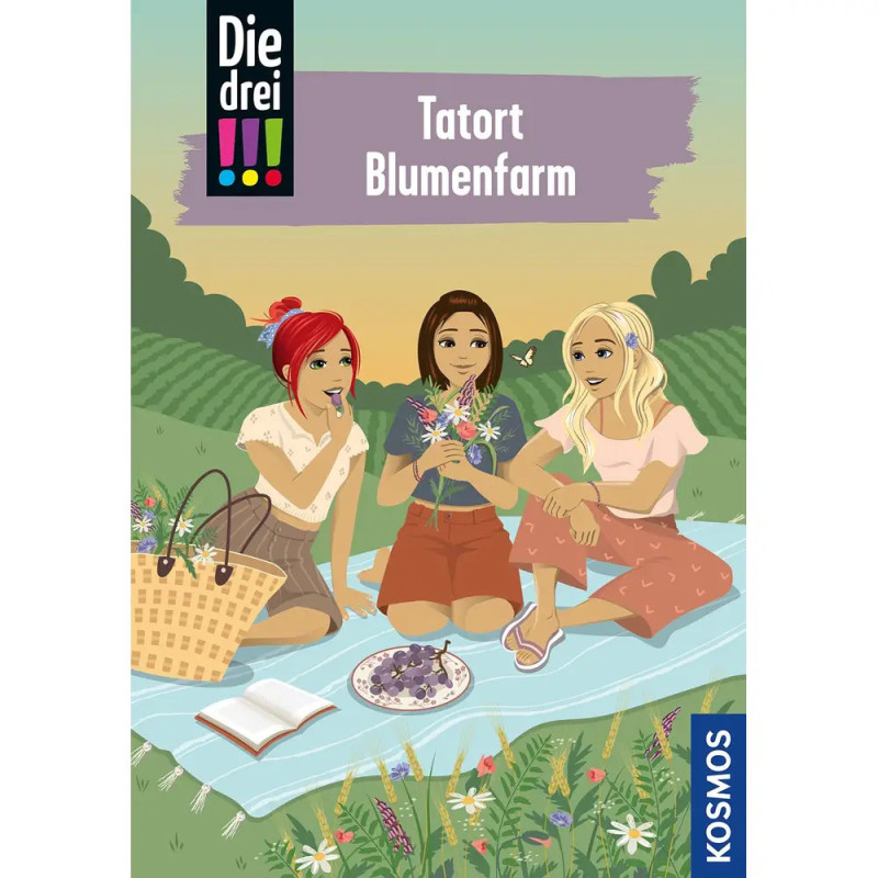 Drei Mädchen sitzen auf einer Picknickdecke im Blumenfeld, unterhalten sich und halten Blumen, ein Korb liegt daneben.