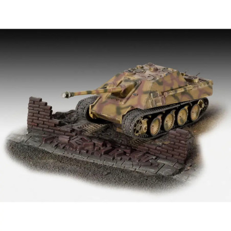 Modellpanzer mit Tarnanstrich steht hinter einer zerbrochenen Ziegelmauer auf strukturiertem Sockel.