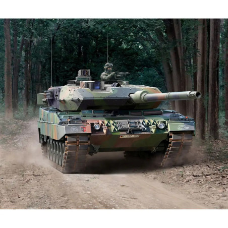 Ein getarnter Militärpanzer fährt auf einem Schotterweg durch einen dichten Wald. Ein getarnter Militärpanzer fährt auf einem Schotterweg durch einen dichten Wald.