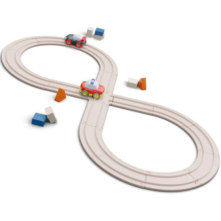 Holzeisenbahn in Form einer Acht mit zwei Spielzeugautos und kleinen, bunten Häusern auf den Schienen.