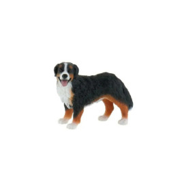 Eine kleine Figur eines schwarz-braun-weißen Hundes steht frontal und streckt die Zunge heraus.