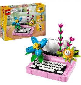 LEGO Creator 3-in-1 rosa Schreibmaschine mit bunten Blumen, aufgebaut und auf der Verpackung abgebildet.