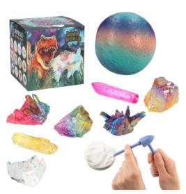 Bunte Kristall- und Edelsteinspielzeuge, eine Dino-Kiste und Hände graben mit Werkzeug in weißem Material.