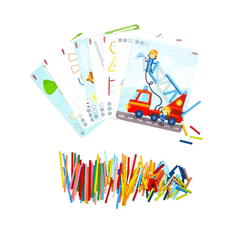 Bunte Karten mit Illustrationen und viele farbige Stäbchen liegen auf weißem Hintergrund verstreut.