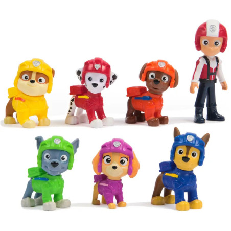 Sieben Paw Patrol Figuren in bunten Uniformen und Helmen stehen in zwei Reihen vor weißem Hintergrund.