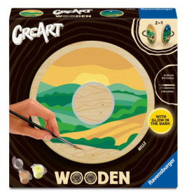 Eine Hand bemalt eine Holz-Landschaft mit Farbtöpfen und Pinseln auf dem CreArt-Holz-Malkasten.