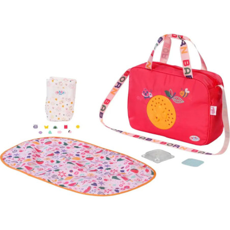 Rotes Wickeltaschen-Set mit bunter Unterlage, Windel und kleinem Zubehör auf weißem Hintergrund. Rotes Wickeltaschen-Set mit bunter Unterlage, Windel und kleinem Zubehör auf weißem Hintergrund.