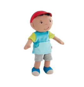 Plüschpuppe mit roter Mütze, blauem Shirt, gestreiften Shorts und blauen Schuhen vor weißem Hintergrund.