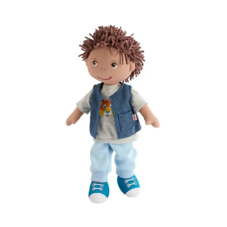 Plüschpuppe mit braunen Garnhaaren, blauer Weste, hellblauer Hose und blauen Schuhen vor weißem Hintergrund.