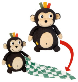 Plüschaffe mit bunten Haarbüscheln zieht eine grün-weiß gemusterte Decke aus seiner Seite.