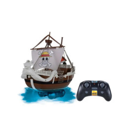 Ferngesteuertes Piratenschiff mit Totenkopfsegel steht neben schwarzer Fernbedienung auf blauem Untergrund.