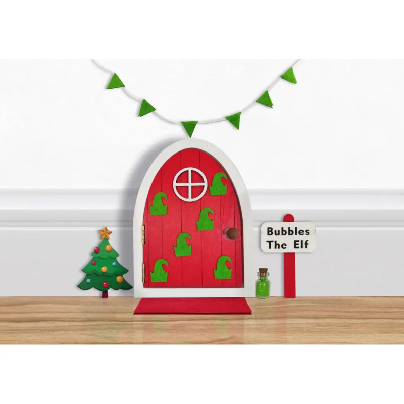 Kleine rote Elfentür mit grünen Hüten, Mini-Weihnachtsbaum und Schild Bubbles The Elf an der Wand. Kleine rote Elfentür mit grünen Hüten, Mini-Weihnachtsbaum und Schild Bubbles The Elf an der Wand.