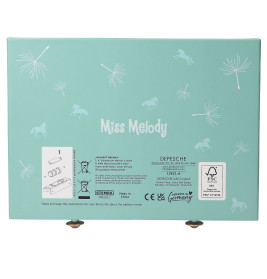 Türkise Miss Melody Box mit weißen Pusteblumen, Pferden und Produktinformationen auf der Rückseite.