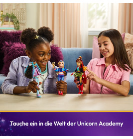 Zwei Mädchen spielen lächelnd am Tisch mit Unicorn Academy Puppen, vor einem lila Hintergrund.