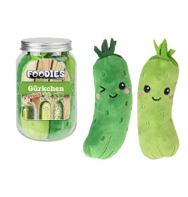 Zwei Plüsch-Gürkchen mit lachendem Gesicht stehen neben einem Glas Foodies Gurkchen mit ähnlichen Figuren.