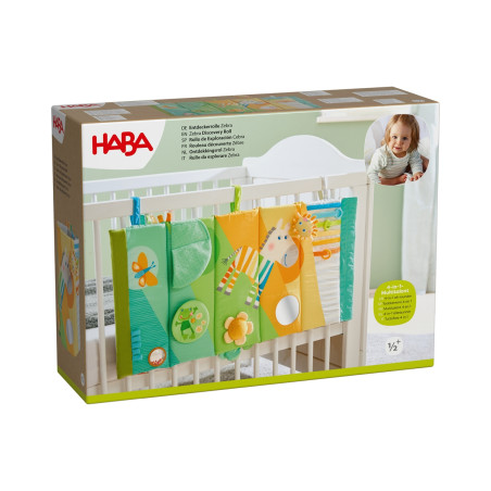 HABA Spielzeugbox fürs Babybett mit buntem Hänge-Panel, Verpackung zeigt lächelndes Baby.