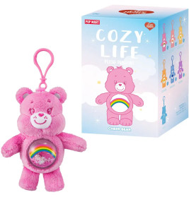 Rosa Care Bear Schlüsselanhänger mit Regenbogenbauch und COZY LIFE Box mit bunten Bärenillustrationen.