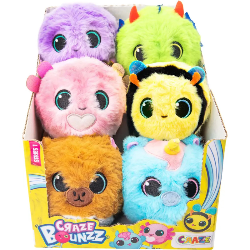 Sechs bunte, runde Kuscheltiere mit Tiergesichtern liegen in einer gelben Craze Bounzz-Box aus.
