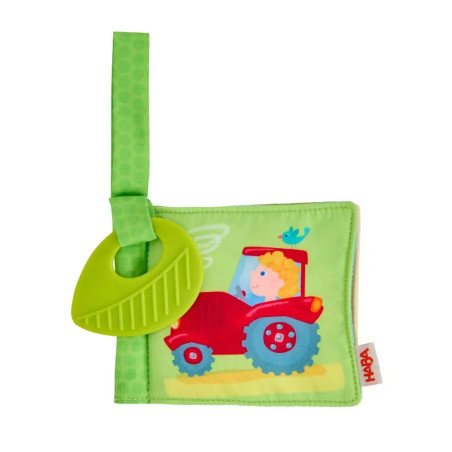 Weiches Babybuch mit grünem Band, rotem Traktor, lächelndem Bauern und blauem Vogel.