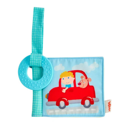 Weiches Babybuch mit rotem Auto, Kind und Hund als Motiv, befestigtem blauen Beißring in der Ecke.