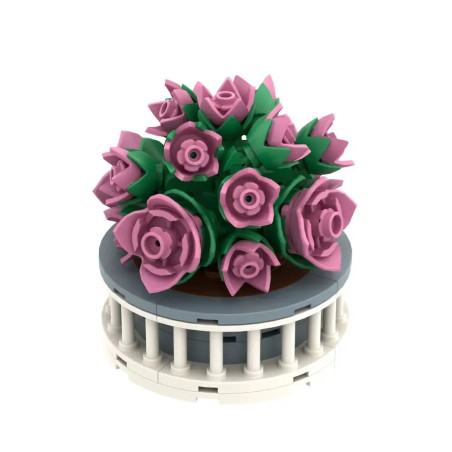 Runde LEGO-Blumendeko mit rosa Blüten und grünen Blättern in einem weißen, runden Topf.