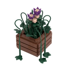 LEGO-Blumenkasten mit lila und beigen Blumen sowie grünen Blättern in einem braunen, rechteckigen Pflanzgefäß.