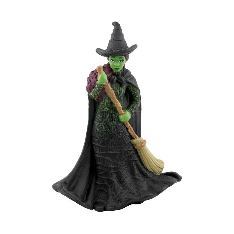 Hexenfigur mit grünem Gesicht, schwarzem Kleid und Hut, hält einen Besen und trägt eine lilafarbene Tasche.
