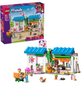 LEGO Friends Set mit Tierklinik, Tierfiguren, Minifiguren und der Setverpackung im Hintergrund.